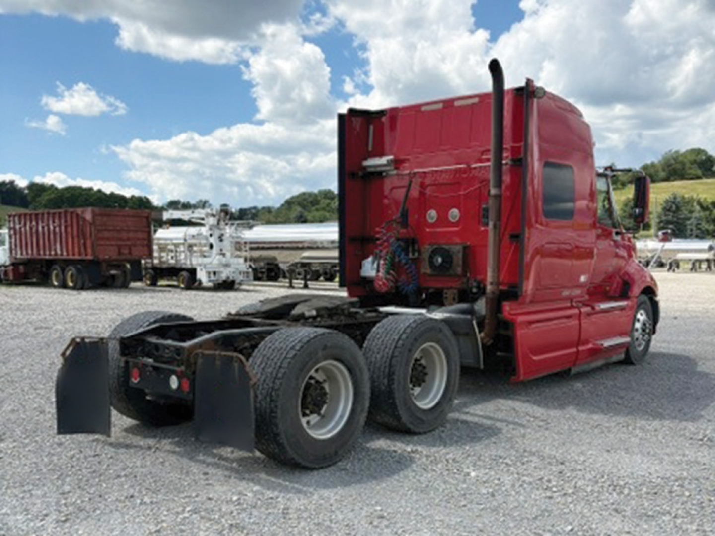 Truck cab and chassis of a red 2008 International ProStar 122 Premium with triple rear axles in a lot.
