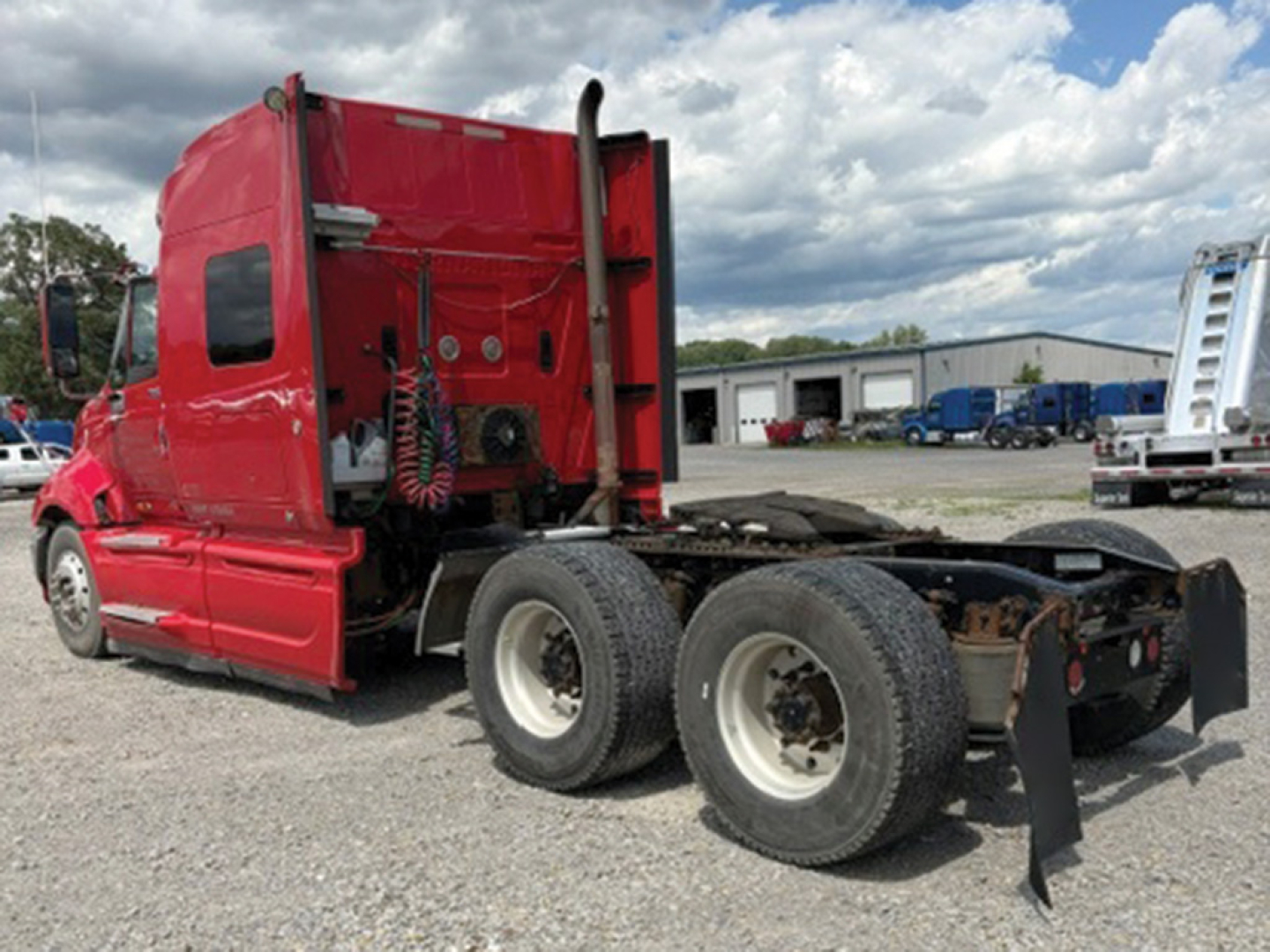 Truck cab and chassis of a red 2008 International ProStar122 Premium with dual rear axles, sleeper cab, viewed from the rear-left side showing rear wheels and fifth-wheel area.