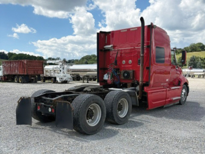 Truck cab and chassis of a red 2008 International ProStar 122 Premium with triple rear axles in a lot.
