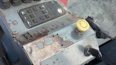 Kalmar DCG160-6T truck crane control panel with keypad and faded yellow cap showing corrosion and rust-free surface; hydraulic reservoir cap visible