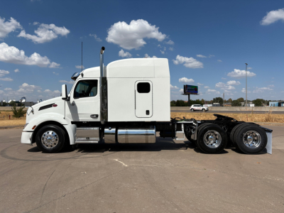 Peterbilt 579 Conventional Sleeper truck in side profile showing white cab and rear chassis with dual rear axles.