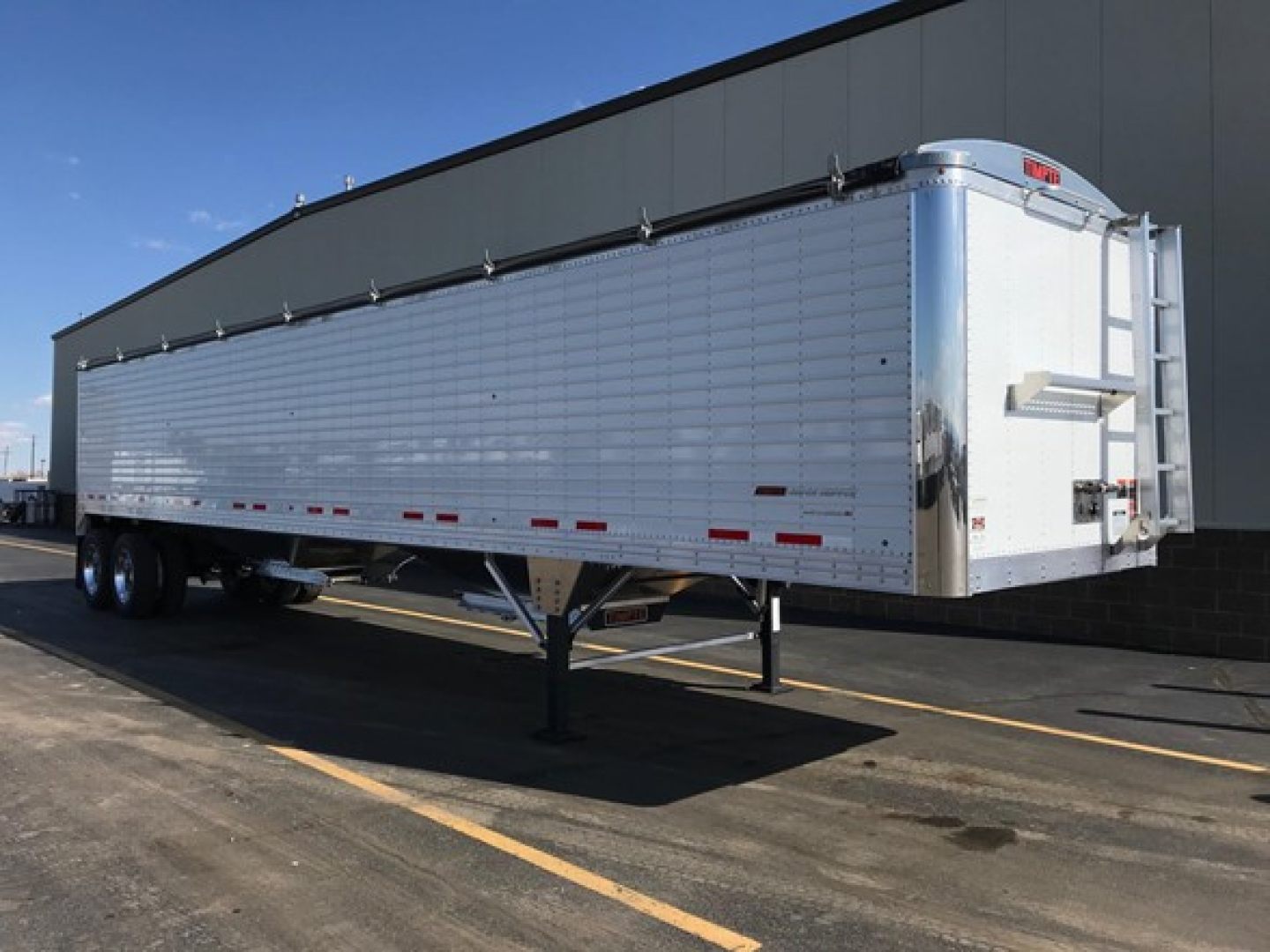 Timpte Super Hopper trailer showing side panel, dual rear axles, and front hitch area with RDS tail.