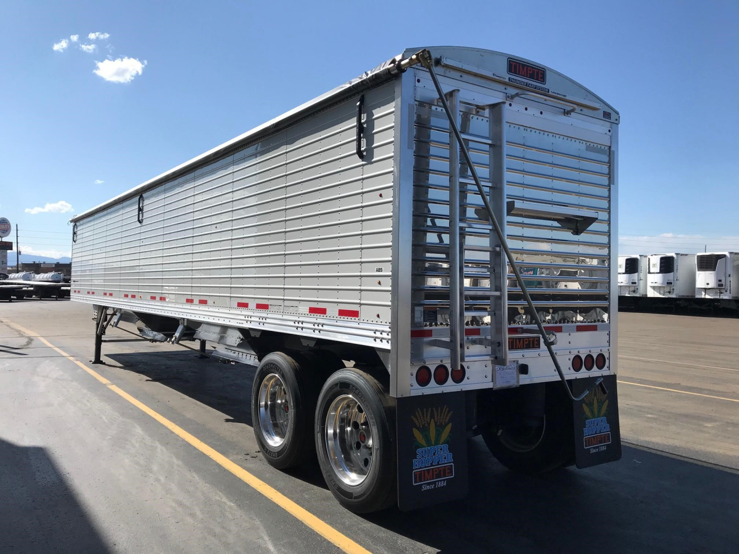 Timpte Super Hopper trailer in a lot showing side and rear with aluminum panels and dual rear wheels.