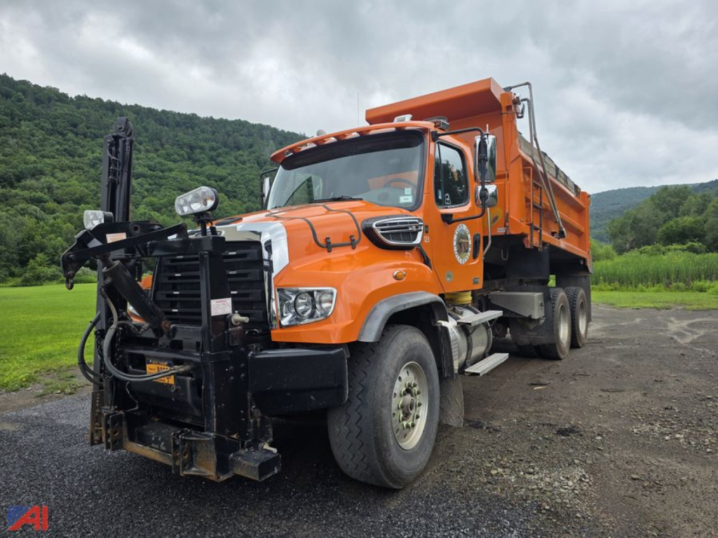 Dump truck 2020 Freightliner 114SD with orange dump body and front grille guard, side view.