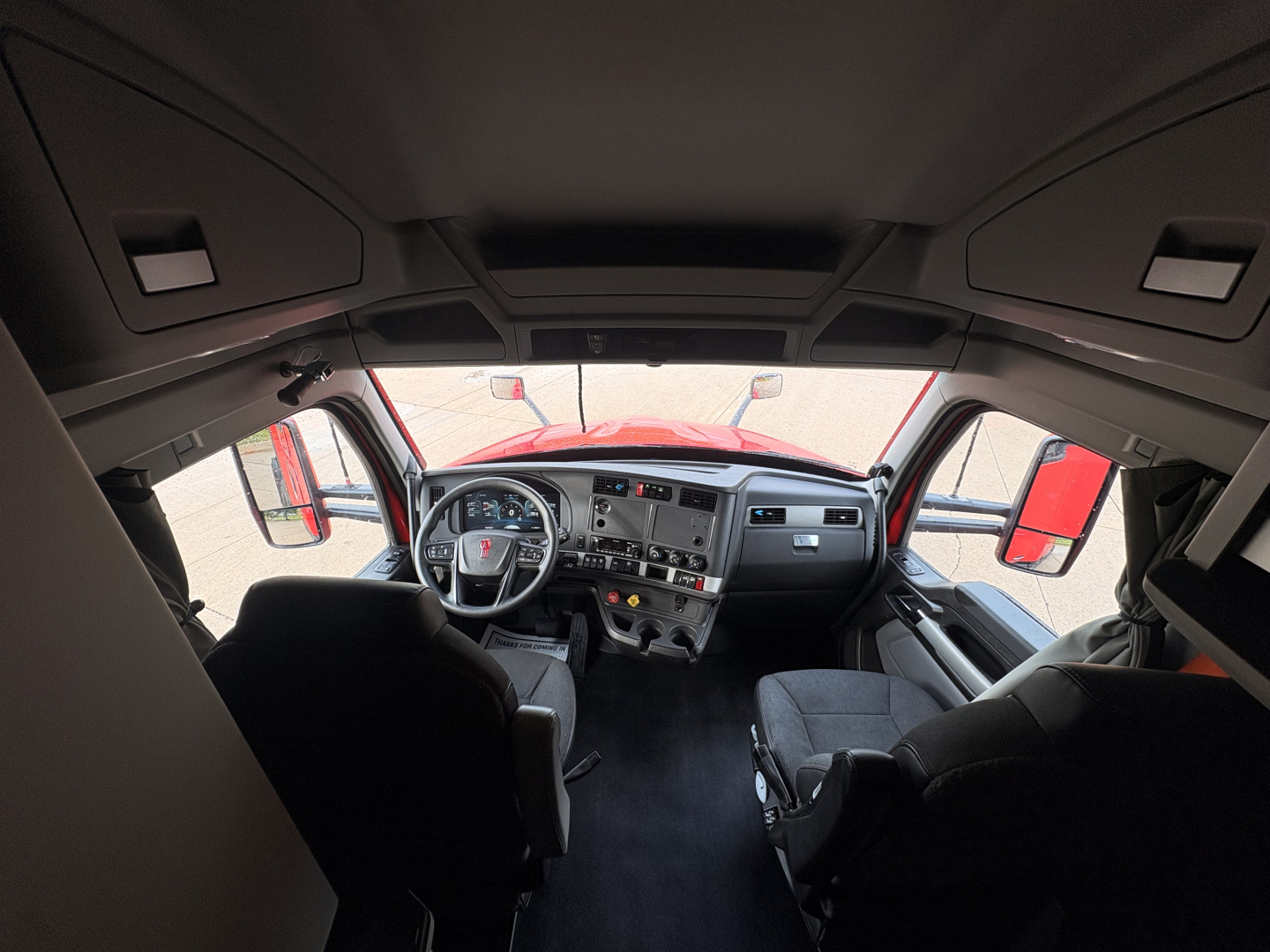 Kenworth T680 interior cab view showing dashboard and steering wheel.
