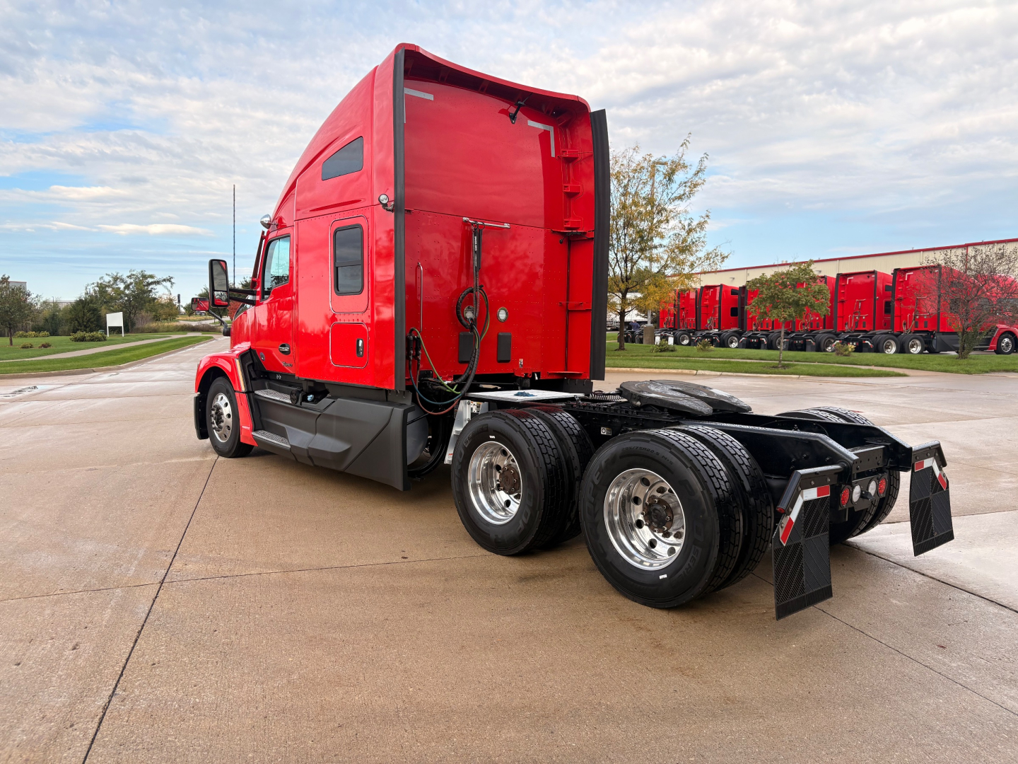 Kenworth T680 truck chassis rear and red sleeper cab, showing left-side view with tandem rear axles and mud flaps.