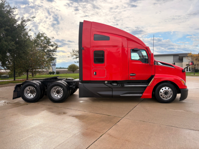 Kenworth T680 tractor cab side view in red with sleeper cab and dual rear axles, chrome wheels, on a wet pavement.