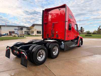 Kenworth T680 tractor-trailer chassis and red cab, rear view showing dual rear axles and fifth wheel plate.