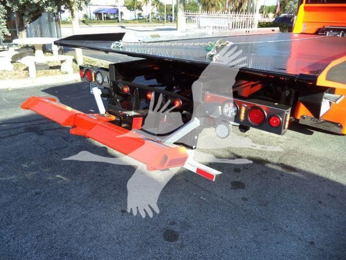 Kenworth T280 rollback truck rear showing platform and ramp with warning lights and reflective tape.