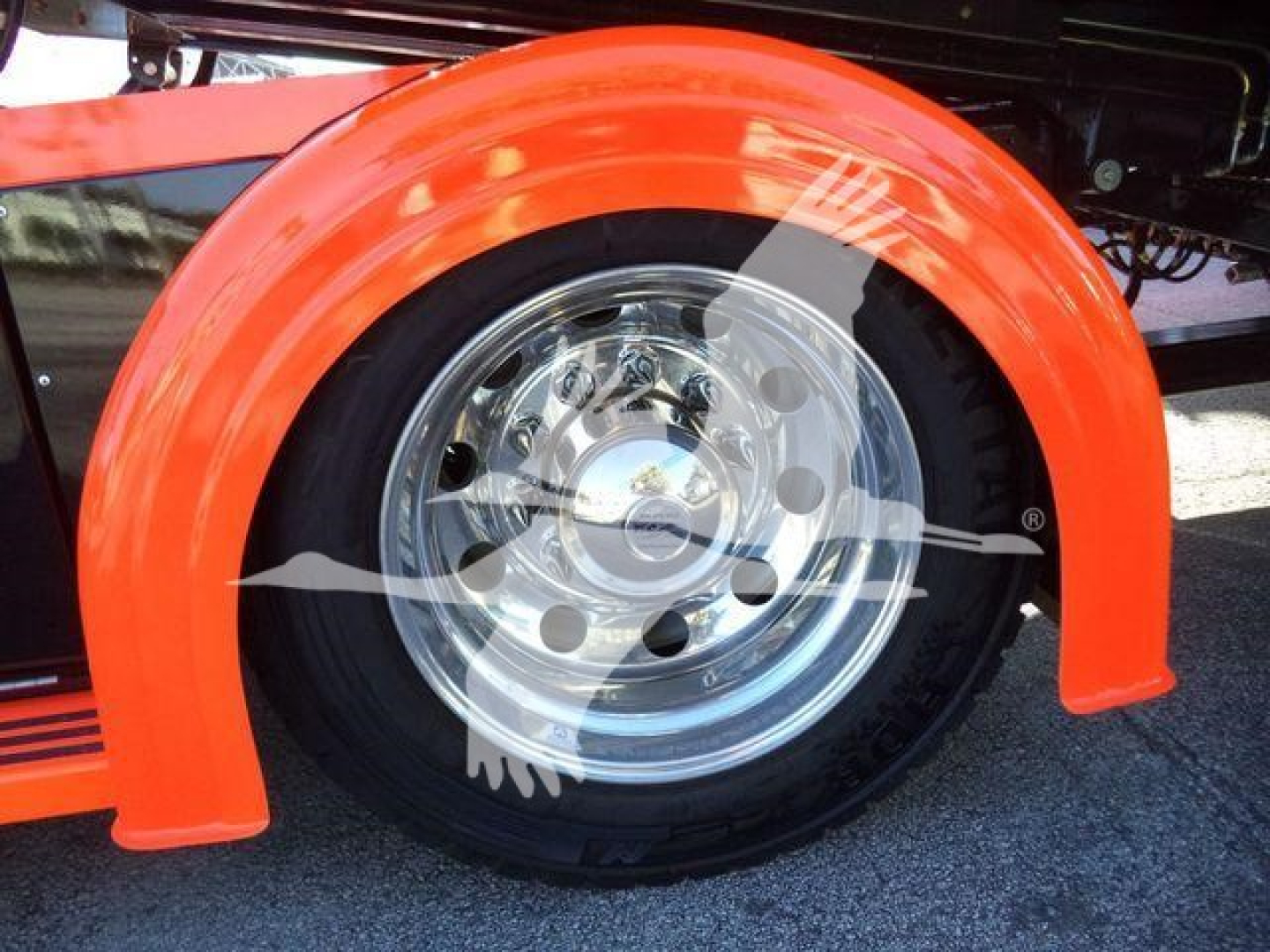 Front wheel and fender of a 2025 Kenworth T280 rollback truck showing chrome wheel and bright orange fender.