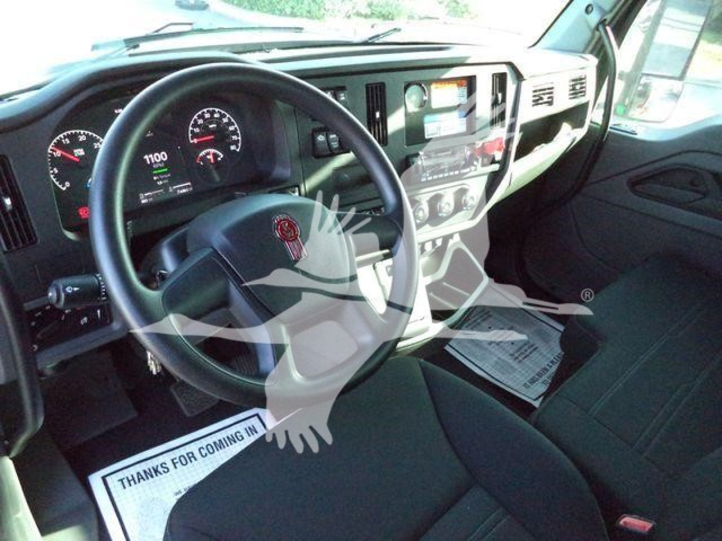 Kenworth T280 cab interior showing steering wheel dashboard and center console with gauges and controls.