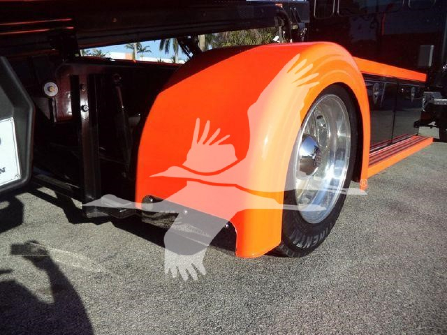 Kenworth T280 side view showing bright orange fender and wheel well with graphic bird design