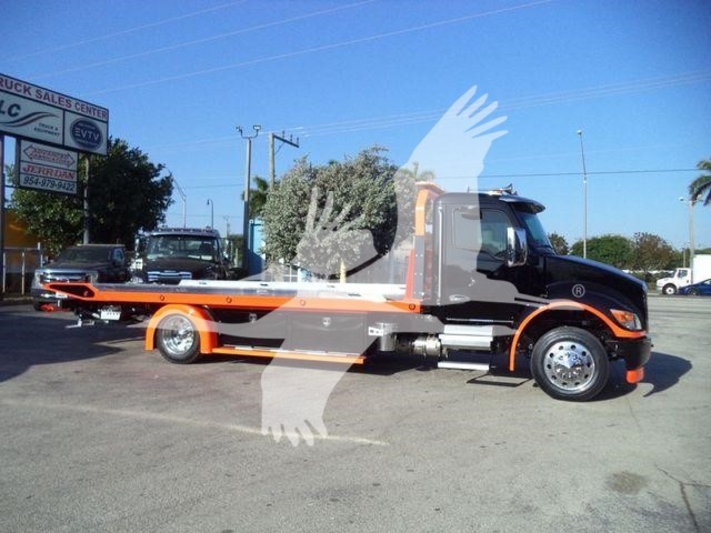 Kenworth T280 rollback tow truck side view showing flatbed and branding on cab.