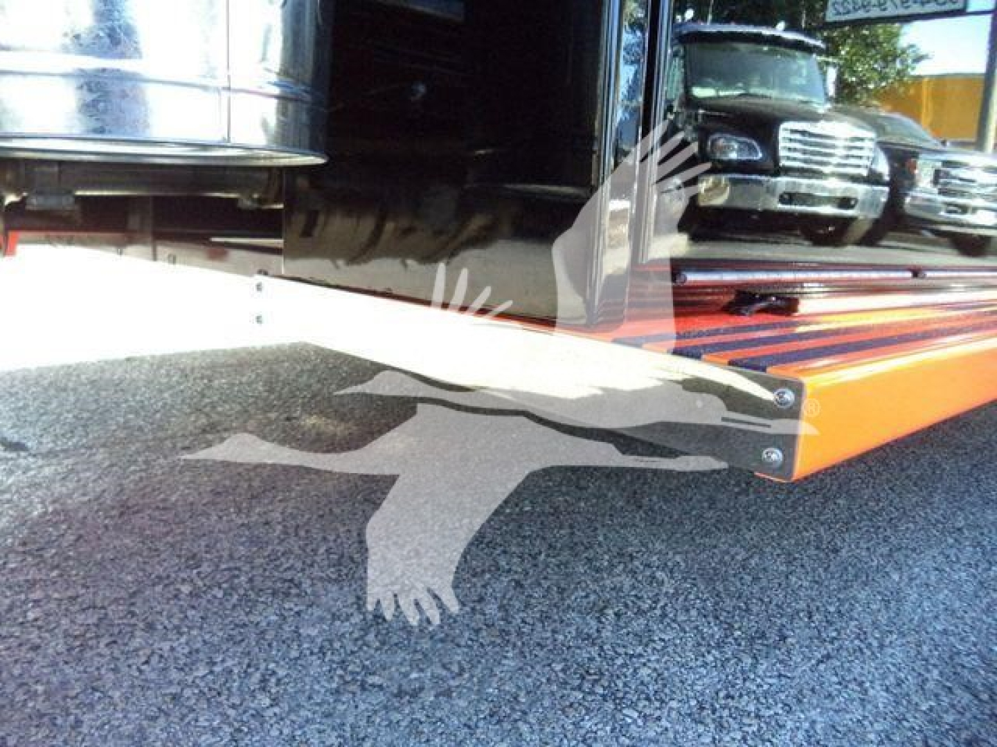 Kenworth T280 rollback truck with loading ramp in view showing side of vehicle and hydraulic components.