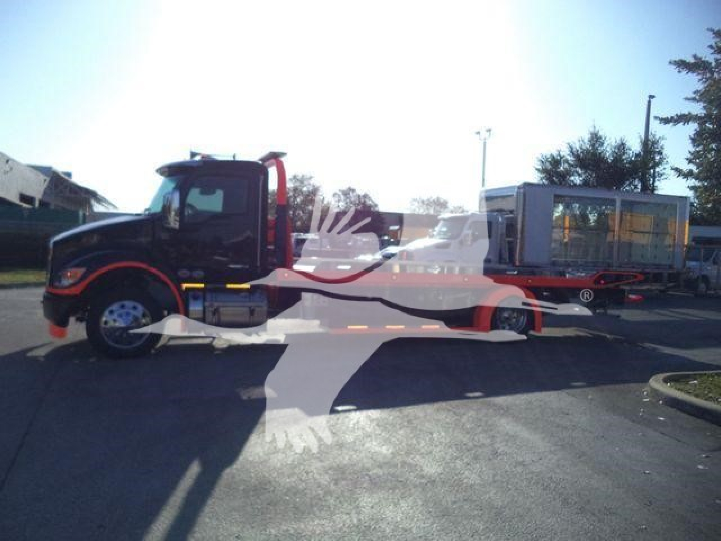 Kenworth T280 rollback truck side view showing cab and lifting bed with attached trailer unit