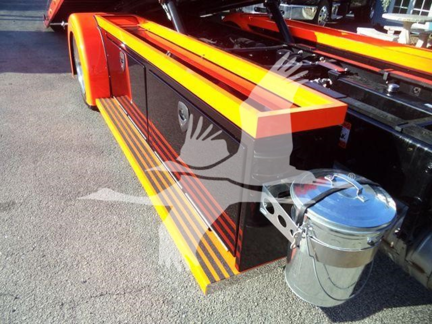 Kenworth T280 rollback truck side with orange and black color scheme showing side steps and chrome fuel reservoir.