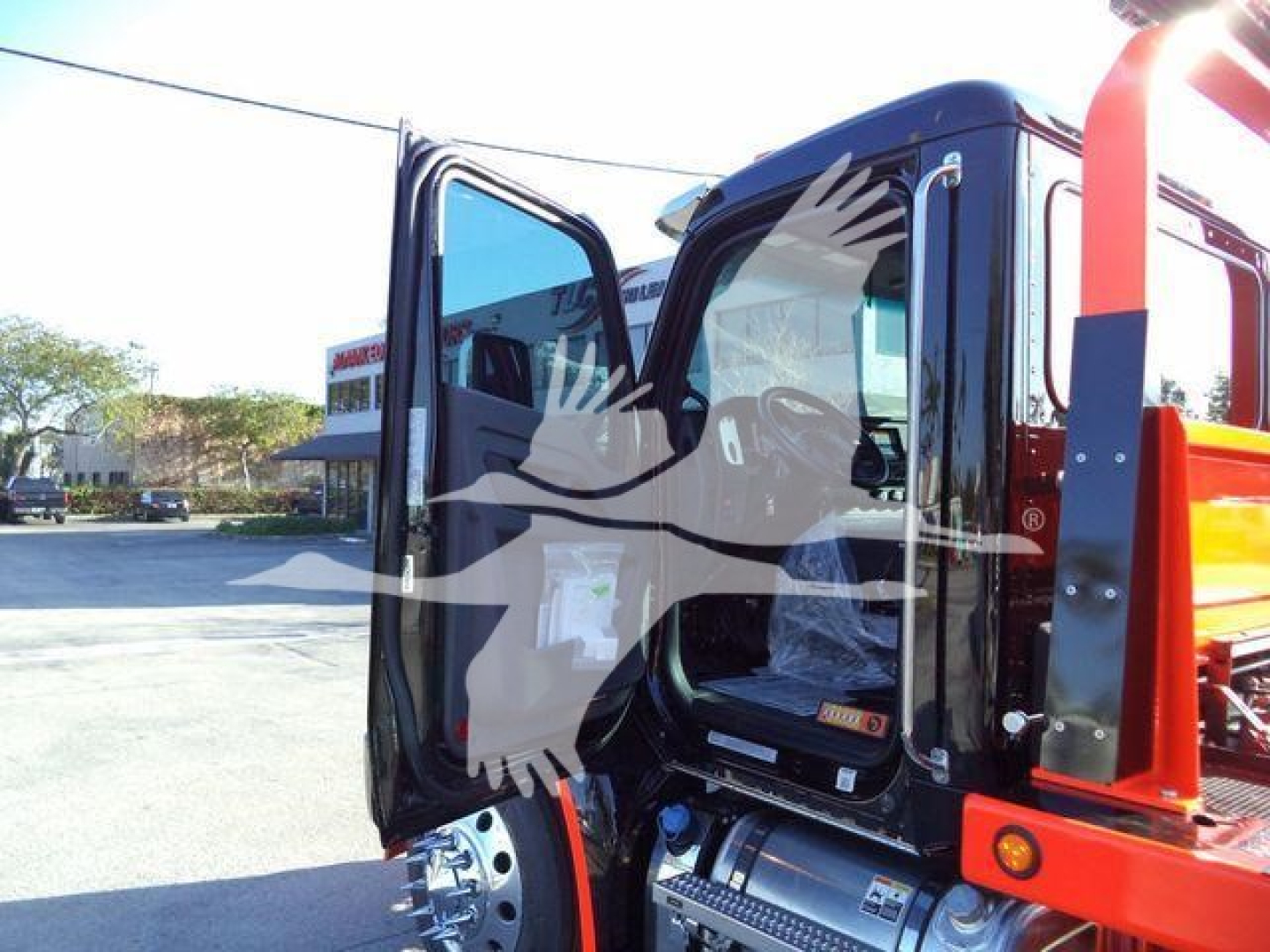 Kenworth T280 truck cab interior with open doors showing dash and seating, part of a rollback truck setup.