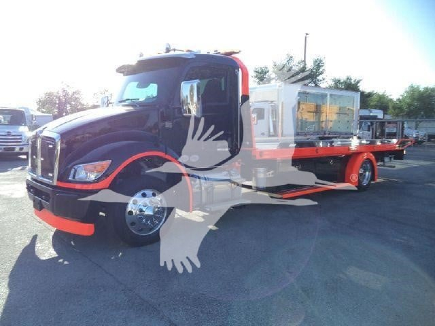 Kenworth T280 rollback truck with extended flatbed and equipment on the bed, side view showing cab and wheels.