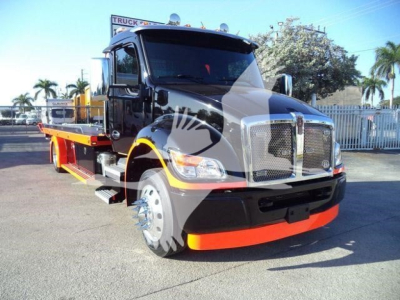 Kenworth T280 truck in black with orange front bumper, flatbed rollback body. Visible text: none clearly readable except stock number area not legible.