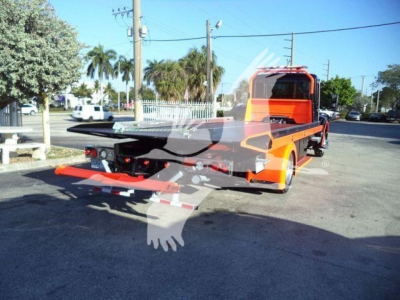 Kenworth T280 rollback tow truck rear view showing vibrant orange body and flatbed at a sunny lot.