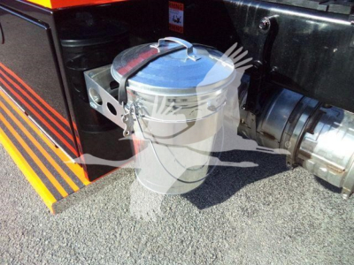 Onside of a 2025 Kenworth T280 rollback truck showing a metal lidded trash can style container mounted near the rear with a metal latch and side exhaust pipe.