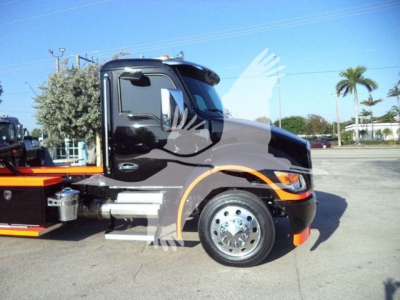 Kenworth T280 truck cab side view showing chrome wheel, black exterior, and rollback bed attachment.