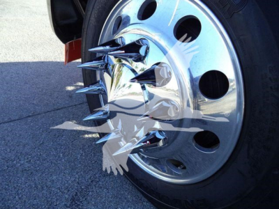 Close-up of a Kenworth truck wheel with chrome hub and multiple sharp metal spikes protruding from the center cap.