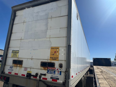 Rear view of a 2015 Hyundai air ride dry van trailer with CAUTION stickers and reflective tape on doors.