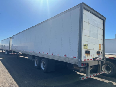 Trailer side and rear showing a long white Hyundai dry van trailer with double rear doors and dual rear axles.