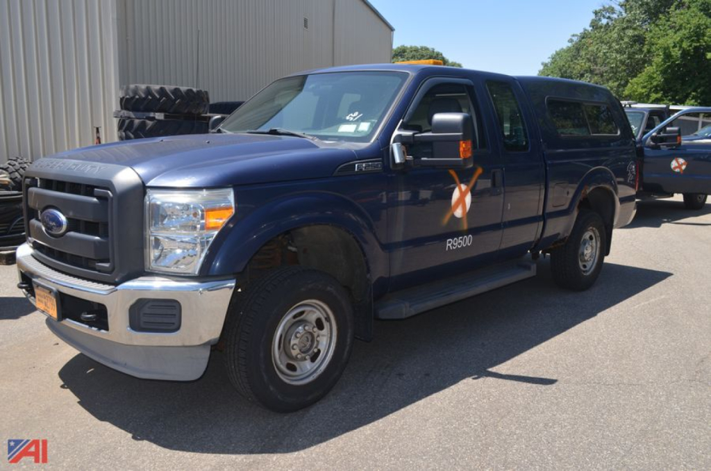 Blue 2012 Ford F-250 Super Duty pickup truck with XL cab and long bed, showing side marker graphic on door and 'R600' decal.