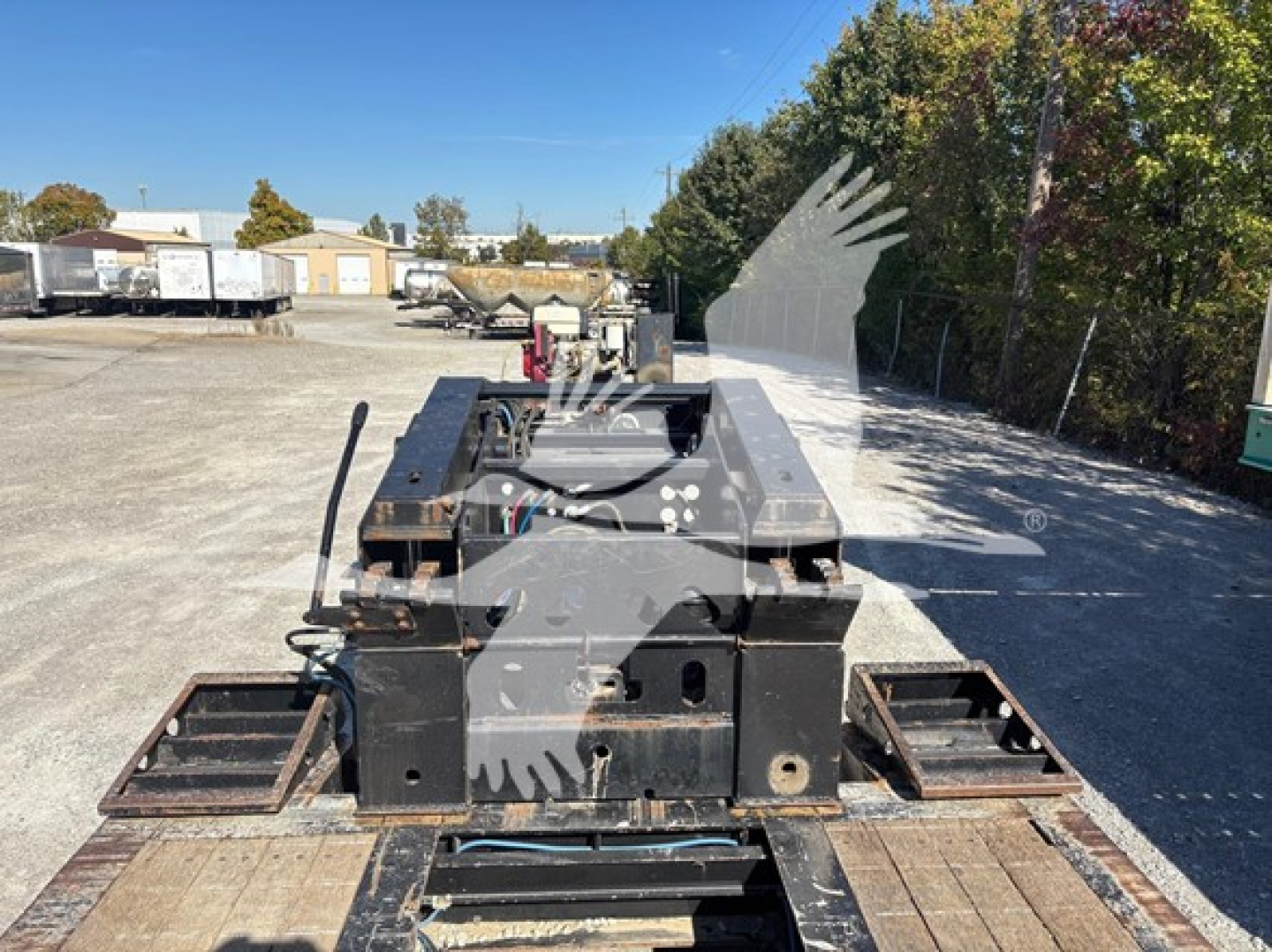 Trailer deck and hitch components of XL Specialized XL80HDG lowboy trailer showing service winches and mounting plates with labels and bolts.