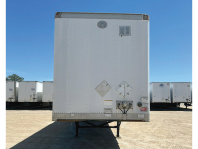 Trailer rear view showing empty white cargo box with diamond hazard placards and taillight area