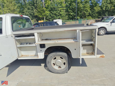 Side view of a 2006 Ford F350 utility truck with open utility body compartments and a single rear wheel visible.