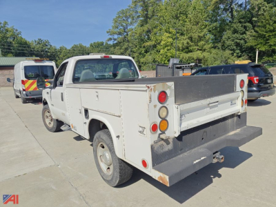 Ford F-350 utility truck rear view showing stake bed with cargo rails and tail lights