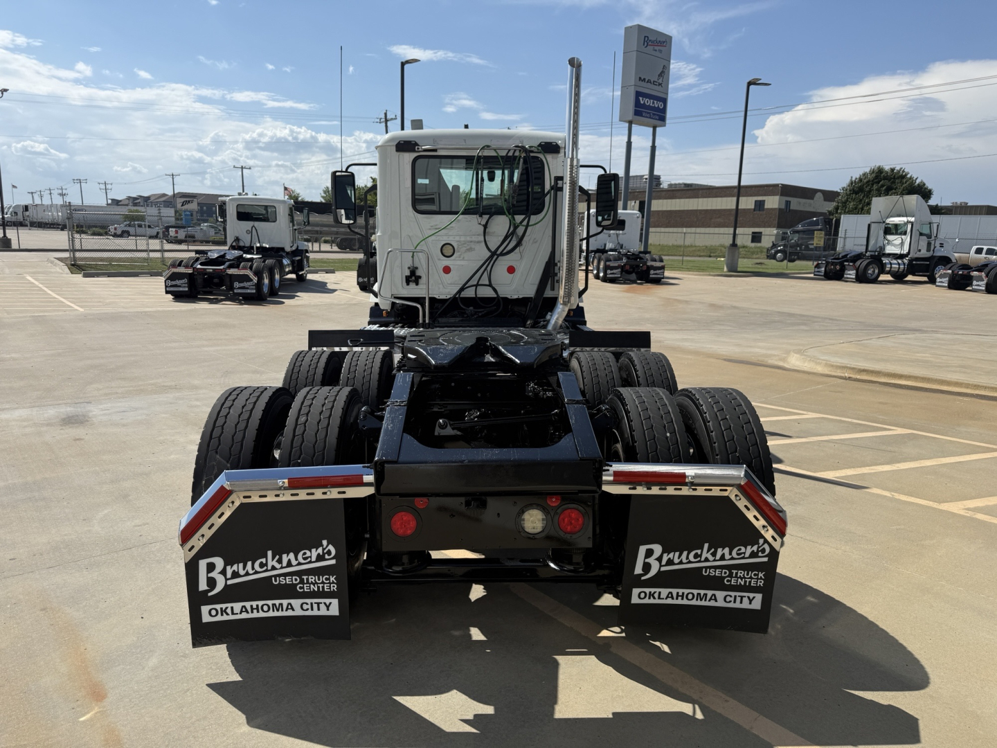 Mack AN64T tractor cab rear view showing dual rear axles with mud flaps labeled Brackner's Used Truck Center Oklahoma City.