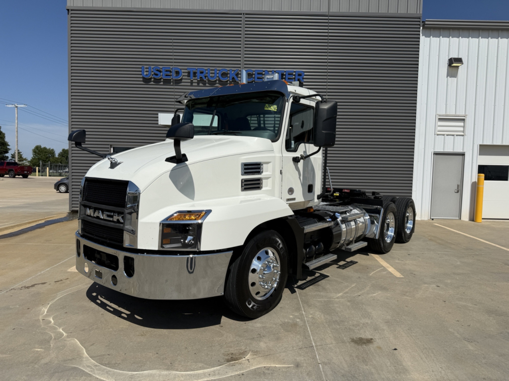 Mack AN64T daycab truck in white the side shows chrome fuel tanks and dual rear axles.
