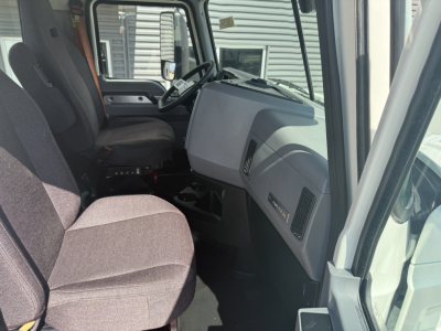 Interior of a 2020 Mack AN64T daycab showing driver seat, steering wheel, and dashboard with gray panels.