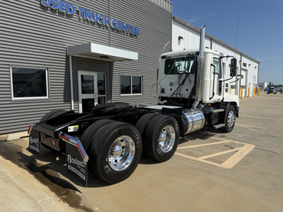 Mack AN64T conventional daycab truck at used truck center showing front and rear axles with dual rear tires and chrome wheels.