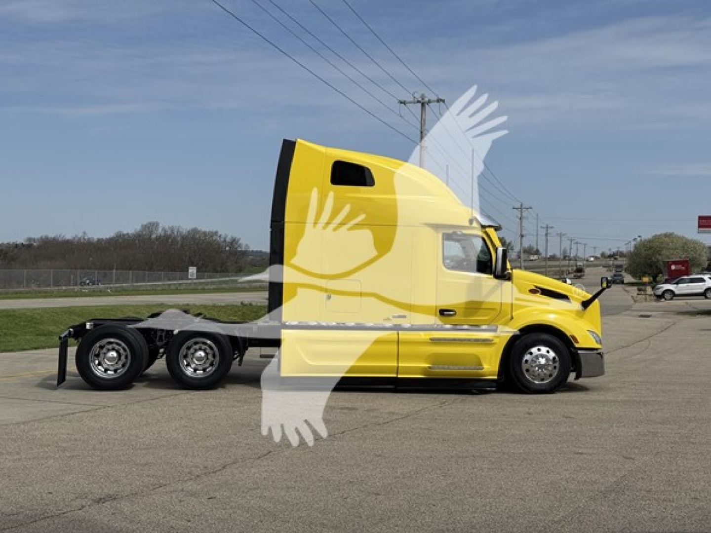 Yellow Peterbilt sleeper tractor with triple axle rear, side view showing cab and fuel tanks, no visible logos or text readable on the side.