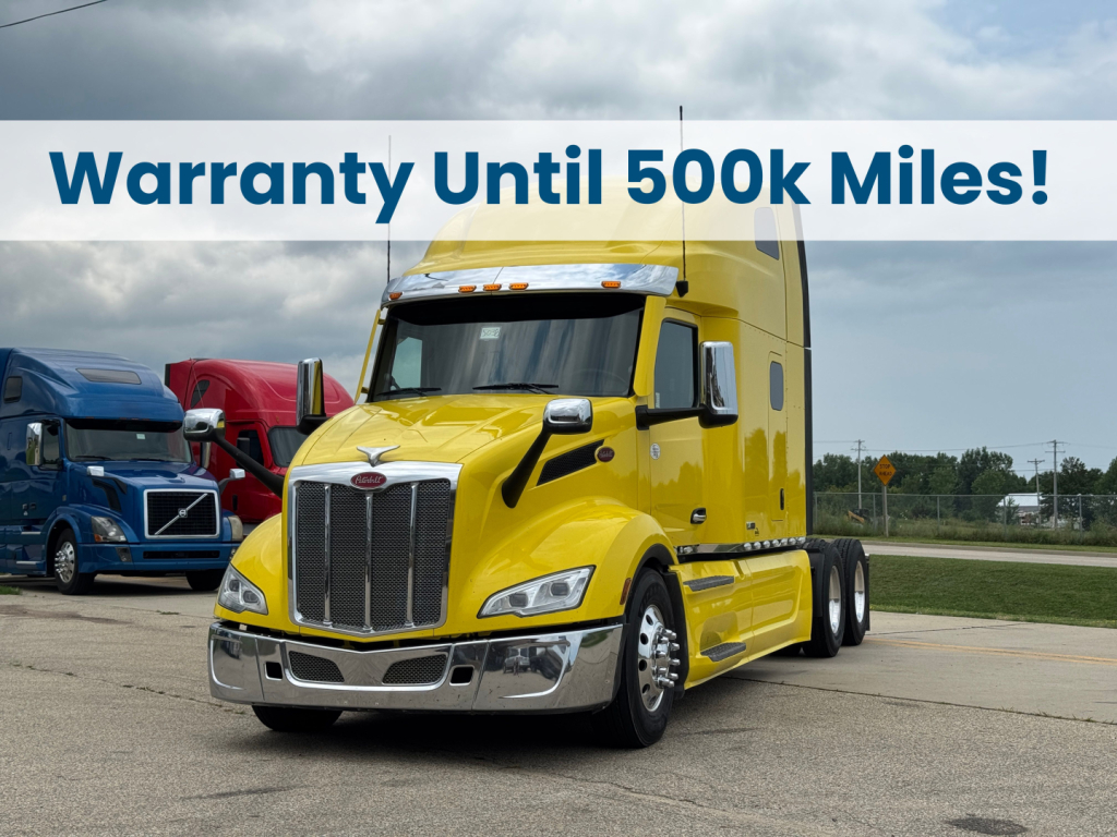 Peterbilt 579 conventional sleeper truck in yellow with Warranty Until 500k Miles banner across top
