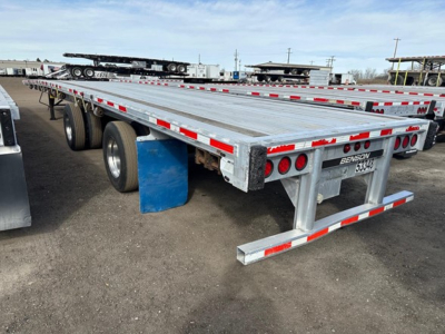 Transcraft 53' all aluminum flatbed trailer showing dual rear axles and reflective red/white tape