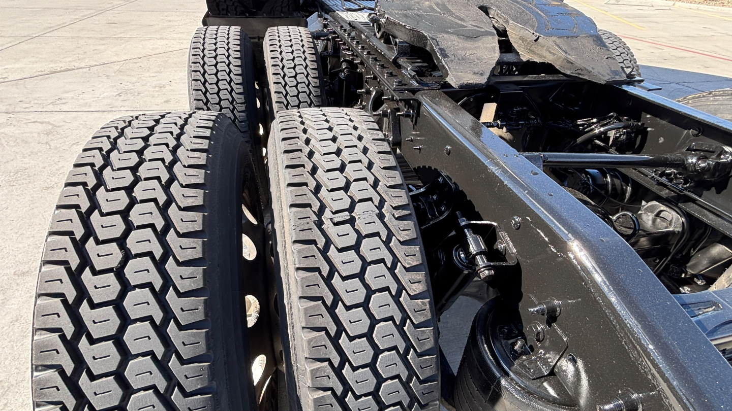 Truck rear dual tires on a tractor chassis showing heavy-duty rims and suspension components.