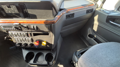 Cab interior of a 2021 International LT625 truck showing dashboard controls, cup holders, and seating area.