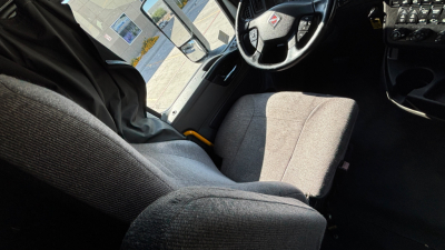 Interior cab view of a 2021 International LT625 showing steering wheel, dashboard, and seat upholstery.