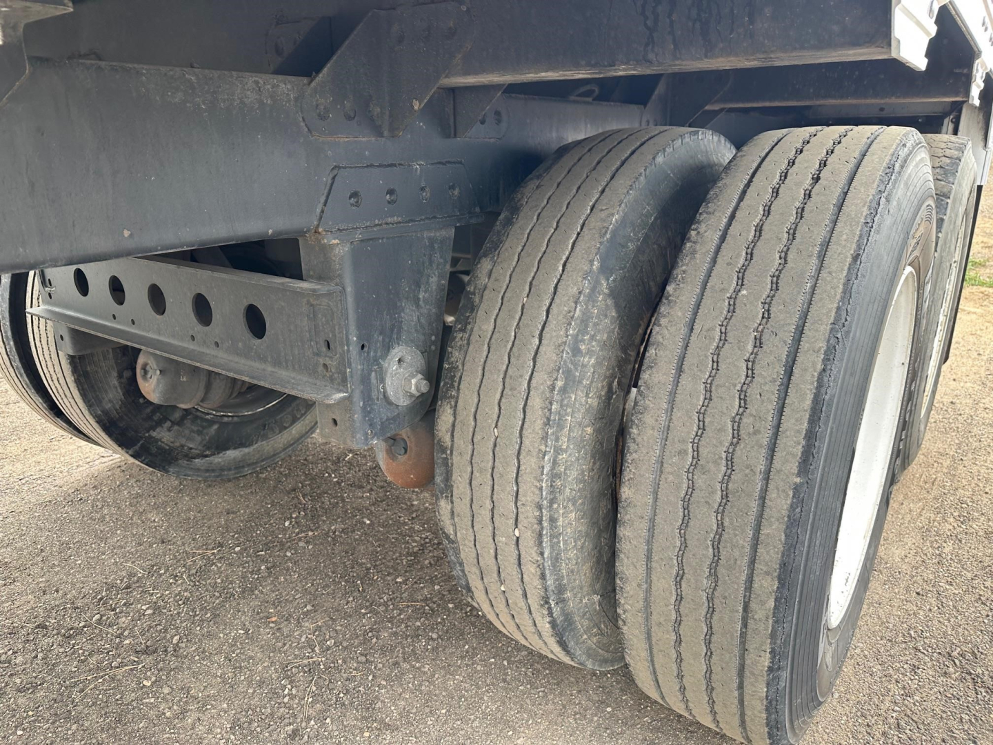 Trailer axle and dual wheels with black frame, inspection of rear dual tires on a 2024 Timpte Super Hopper W 78 inch sides.