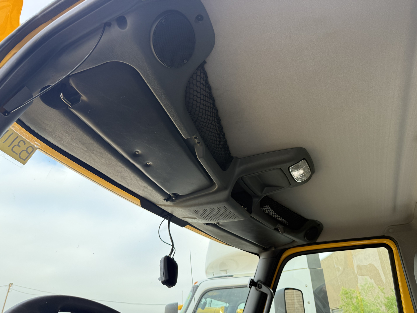 Cab interior of a 2019 International LT daycab showing overhead dashboard area and sun visor with rearview mirror hanging device.
