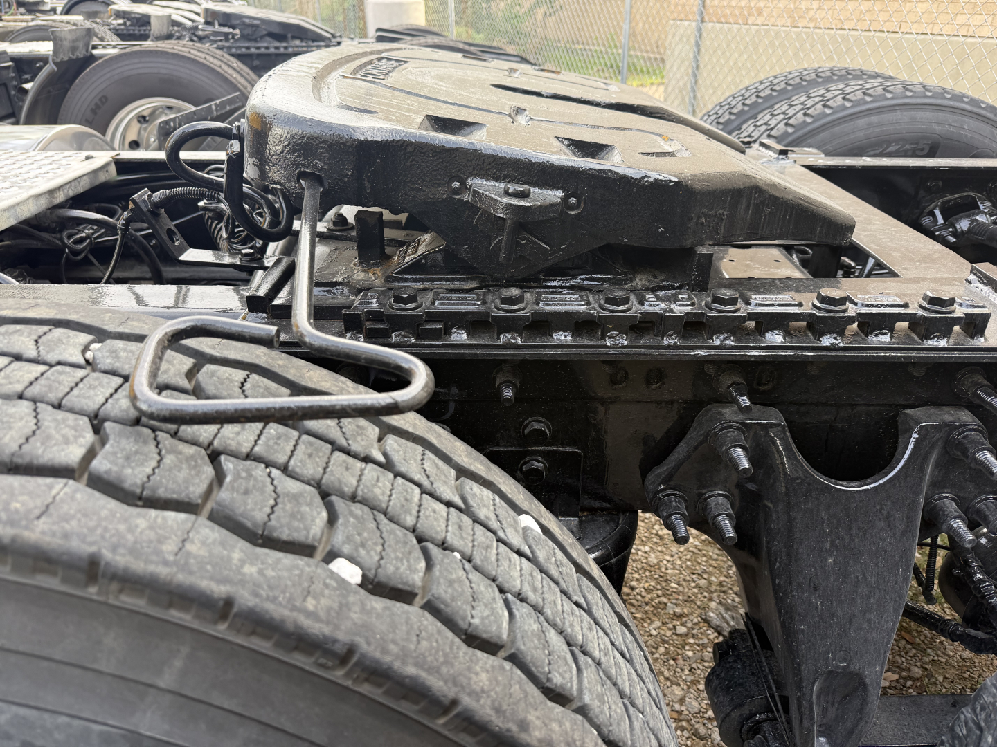 Truck chassis showing fifth wheel, battery box, and frame rails with tires in view.