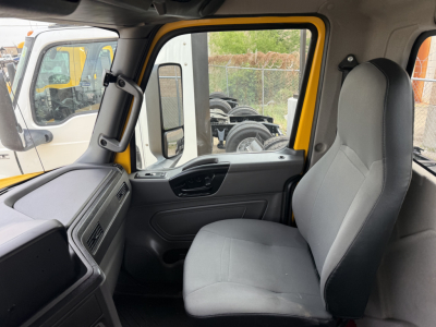Interior view of a 2019 International LT truck cab showing grey fabric seat, front passenger area, window controls, and yellow exterior frame.