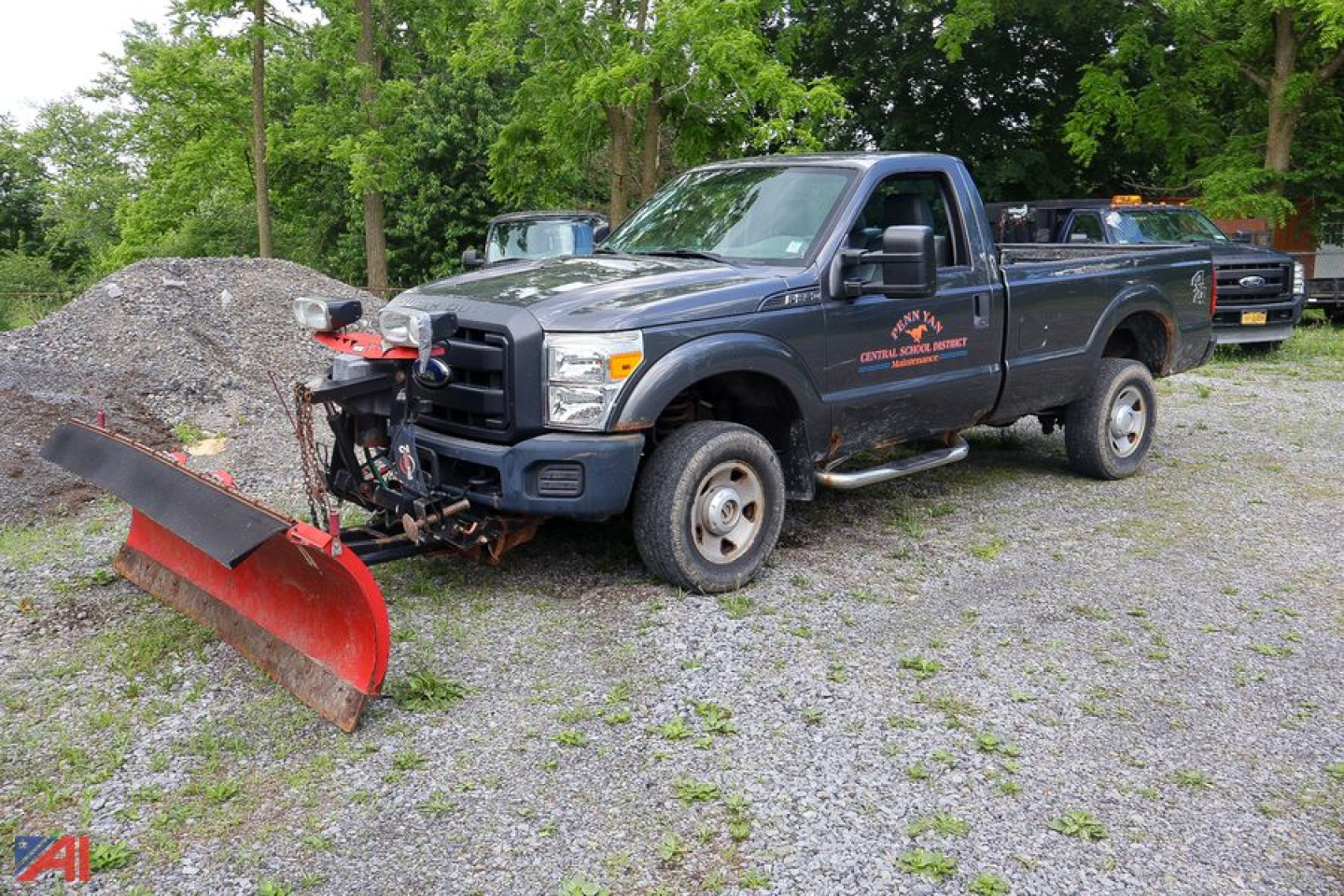 Ford F-250 Super Duty pickup with plow attachment in a gravel lot, utility truck with snow plow ready for use.