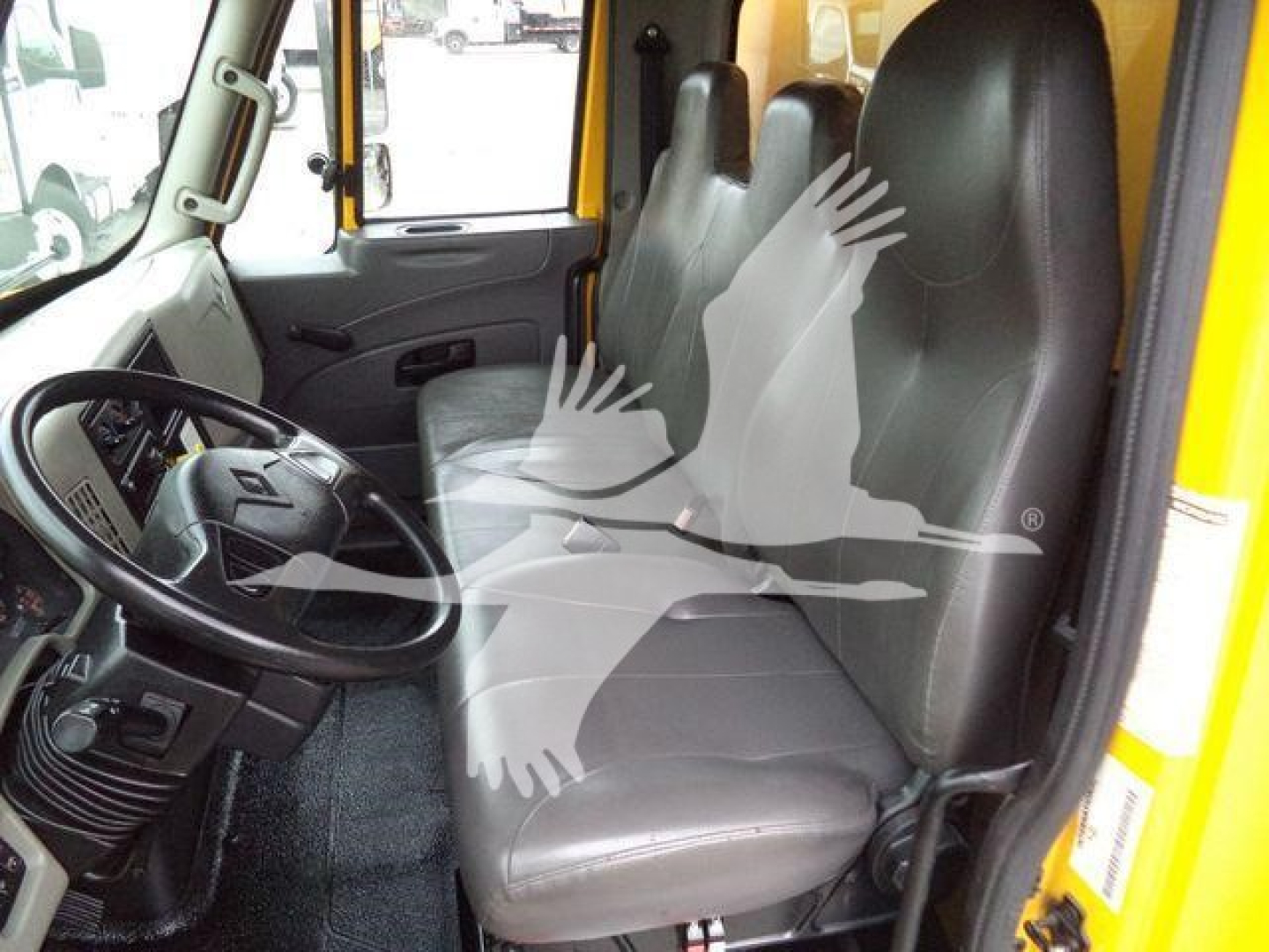 Interior of a 2019 International Durastar 4300 truck cab showing driver seat and passenger seat with steering wheel and dashboard visible.